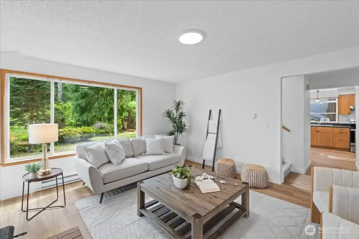 Living Room – Bright and inviting living area with expansive picture window overlooking the landscaped yard. Open layout provides easy flow to adjacent living spaces.