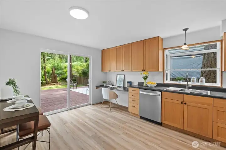 Kitchen – Kitchen with abundant cabinetry, built-in workspace, and sliding glass door access to the outdoor deck. Large windows provide natural light and backyard views.