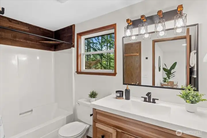 Bathroom – Full bathroom with updated vanity, modern fixtures, and tub/shower combination. Window brings in natural light and views of the surrounding greenery.