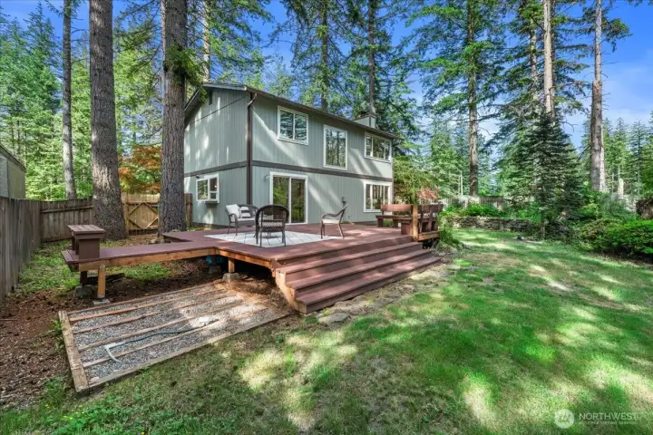 Backyard – Expansive deck overlooks the fenced backyard and mature landscaping. Multiple seating areas create space for outdoor dining and relaxation.