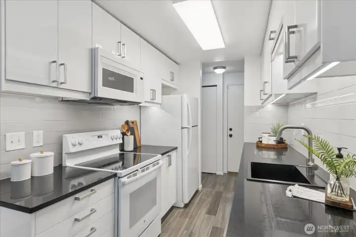 Beautiful white cabinets, black quartz countertops and newer appliances.
