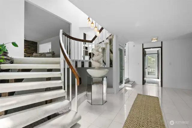 This grand foyer is central to the design of the home with access to the upper and lower floors as well as the exterior. A flex room & 3/4 bathroom on this level offer main level living if needed.