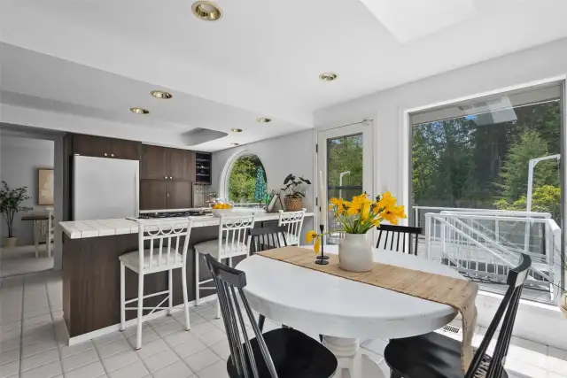 A bright, open kitchen features separate deck access and additional counter seating, perfect for quick morning bites!