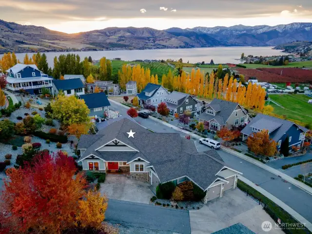 Aerial view of west facing home w/ uplake views of Lake Chelan w/ attached 3-car garage set on a large 14.850sf lot adjacent to The Lookout's hilltop park and pool.