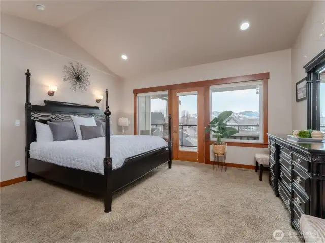 View of the spacious main level Primary Bedroom Suite w/ French doors leading to the lake view deck and outdoor living area.