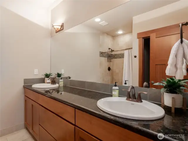 View of lower level 2nd Primary Bedroom Bathroom suite w/ double vanities, quartz countertops and European tiled showers.
