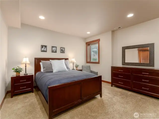 View of lower level guest bedroom 2 w/ queen sized bed and walk-in closet.