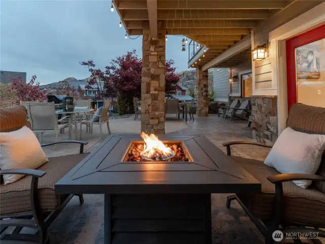 Twilight view of lower level outdoor living area w/ dining, lounge and BBQ area.