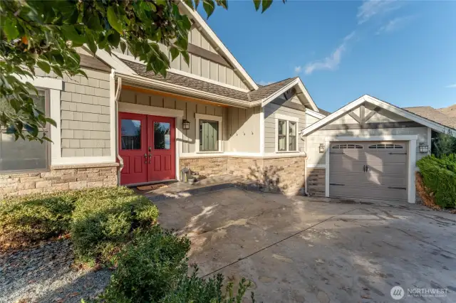 Exterior view of front door and driveway w/ 3-car attached garage.
