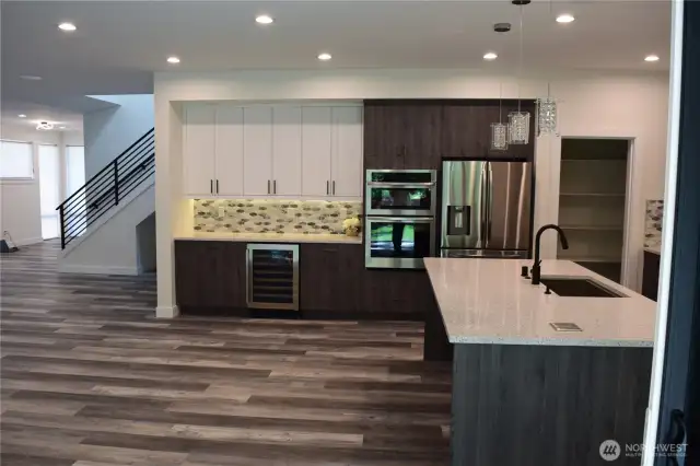 Another view of the Gorgeous Dry Bar with Wine Fridge. Large Dining Island with Beautiful Slab Quartz Countertops.