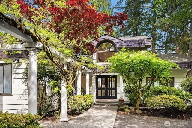 Mature wisteria frames the entryway trellis offering a sense of arrival and presence.