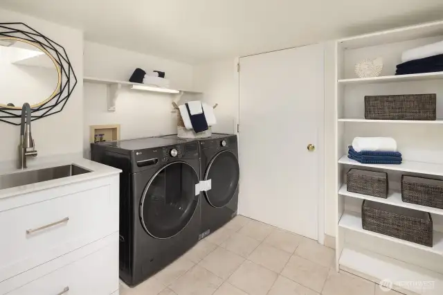 This spacious laundry room sports brand new washing machine and dryer set.