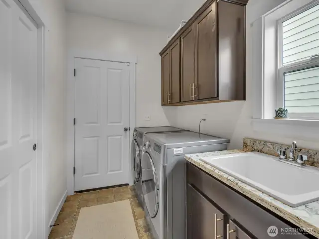 Laundry room with sink, cabinetry plus a walk-in closet.