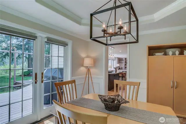 Formal dining with french doors to deck and beautiful landscaping