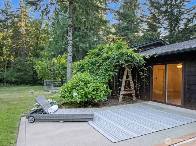 Patio off the detached office/storage building leading out to the large back yard