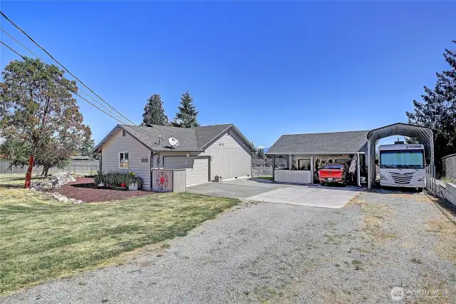 attached 2 car garage, carport that fits 2 cars + bonus rooms for shop and storage, additional storage in upper part of carport + RV covered parking