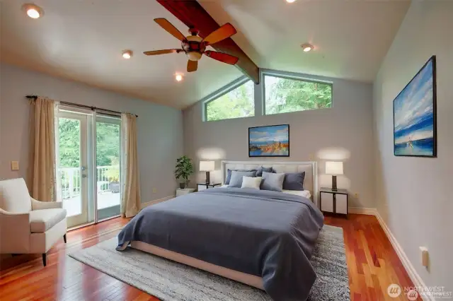 Main floor primary suite with deck overlooking the property.