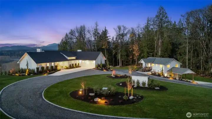 Meticulously remodeled estate has been professionally landscaped and adorned with lighting and cement curbing detail.