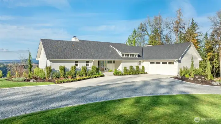 New driveway pad, custom carriage house garage door, professional landscaping with curbing.