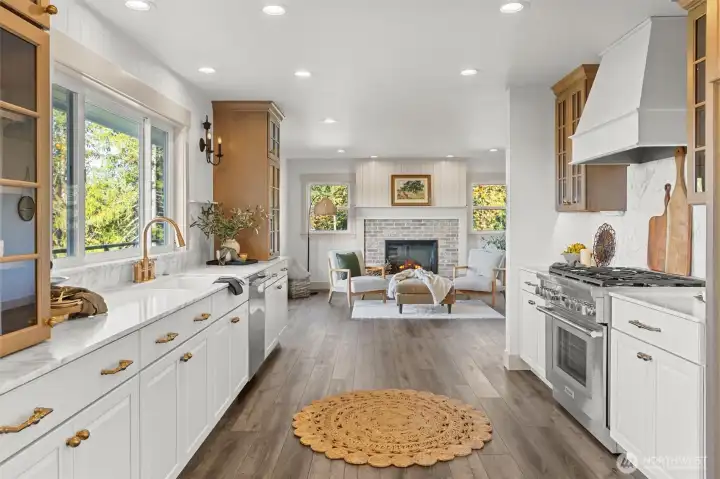 Chef's kitchen with high-end Thermador appliance package, including 6-burner gas stove, custom vent hood, marble countertops and backsplash and undercabinet lighting, on dimmers.