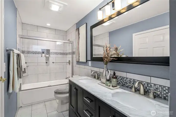 Fully tile surround and updated vanity, lights and flooring.