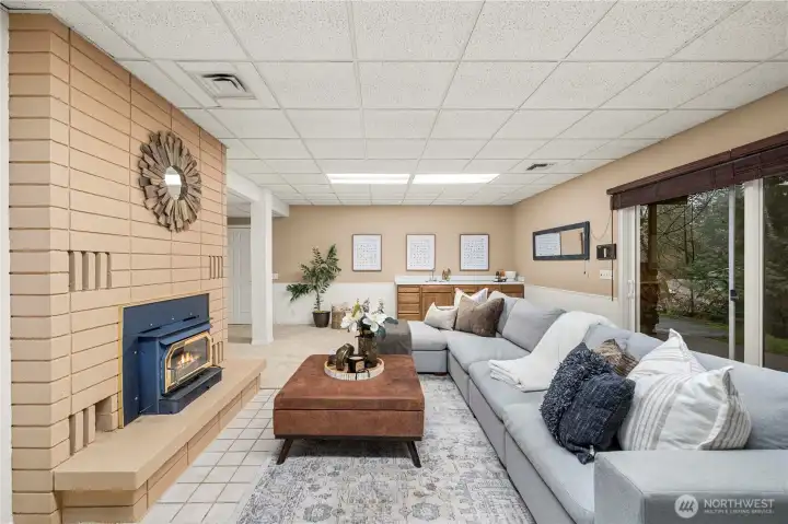Wood burning stove, large fireplace surround and a wet bar make this huge space cozy and great for entertaining or movie nights at home.
