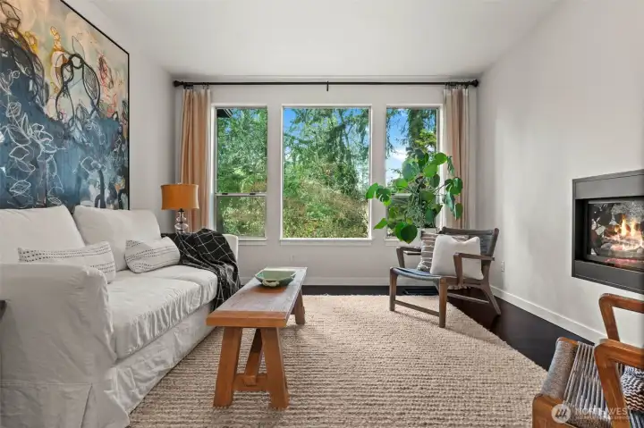 den with double sided fireplace and oversized window overlooking private backyard