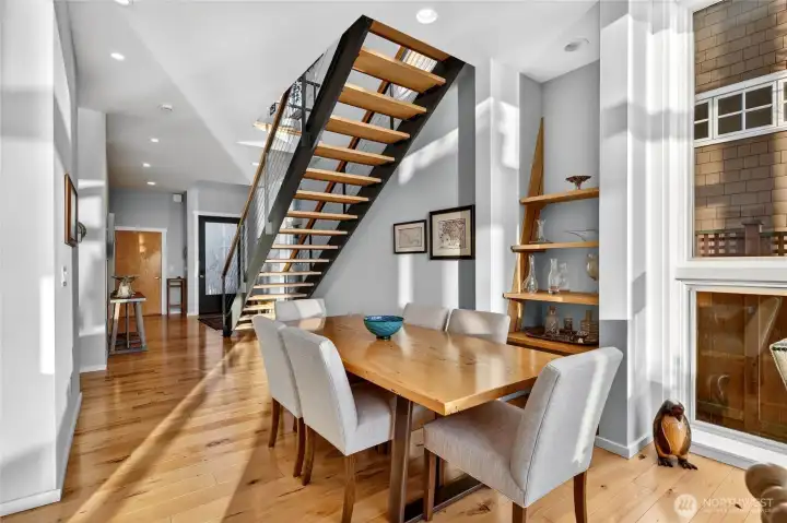 Looking back toward the entry, a floating staircase of steel and wood anchors the space with understated drama.