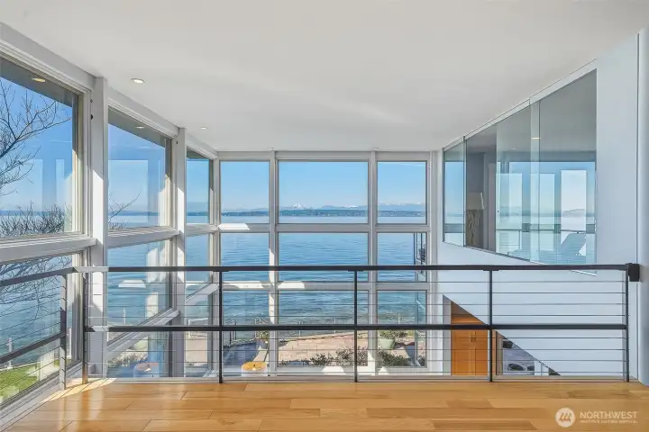 The upper-level family room opens to the same sweeping views, looking down over the living space below.