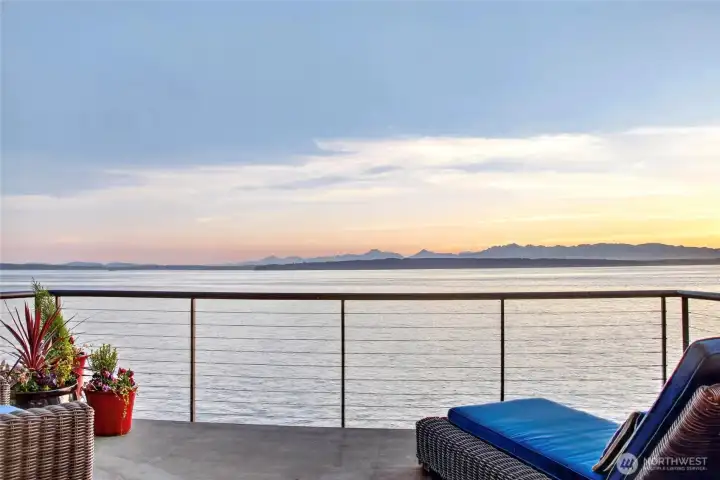 The primary bedroom's private balcony, with the Sound and Olympics stretching to the horizon.