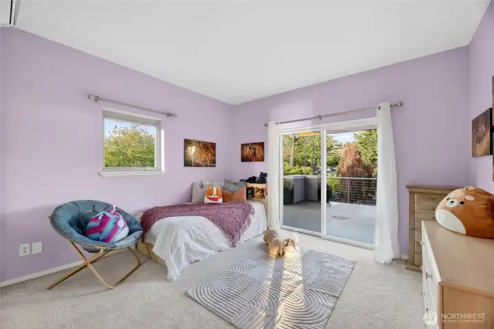 One of two east-facing bedrooms, with sliding doors opening to a spacious patio.