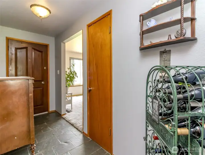 Slate floor, solid wood door and coat closet in front entrance.