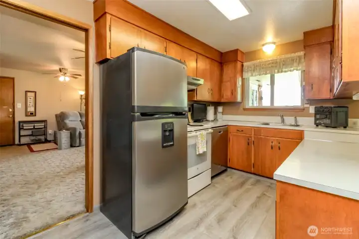 Luxury vinyl flooring and solid wood cabinetry in kitchen.