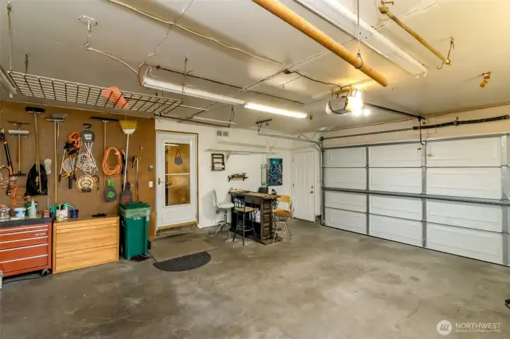 Nice 2 car garage has easy access into home and two walk-thru doors to the front and back yards along with a work bench, overhead storage and pull down attic access that has storage too!