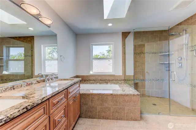 The en-suite bathroom features a dual-sink vanity, soaking tub, separate shower