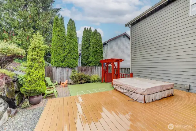 The backyard is a true retreat, featuring a relaxing hot tub and a dedicated play area