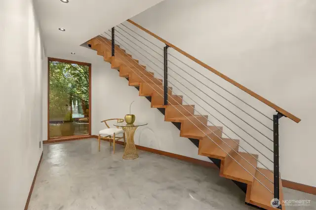 Architectural stairwell adds warmth and modern flair.