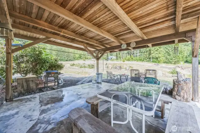 Large Covered Patio with Cement floor, right off of Family room. Behind the BBQ is the swimming pool pad.