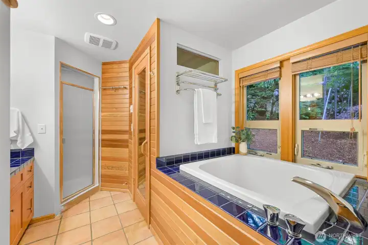 The spa-inspired bathroom includes a soaking tub, sauna, separate shower, and warm wood finishes for a true retreat experience. The spa-inspired bathroom includes a soaking tub, sauna, separate shower, and warm wood finishes for a true retreat experience.