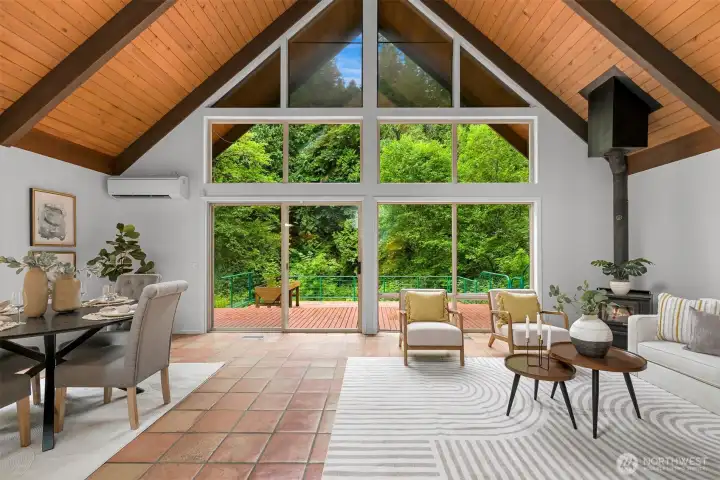 Dramatic wall of windows overlooks the surrounding greenery and opens directly to the spacious deck. Dramatic wall of windows overlooks the surrounding greenery and opens directly to the spacious deck.