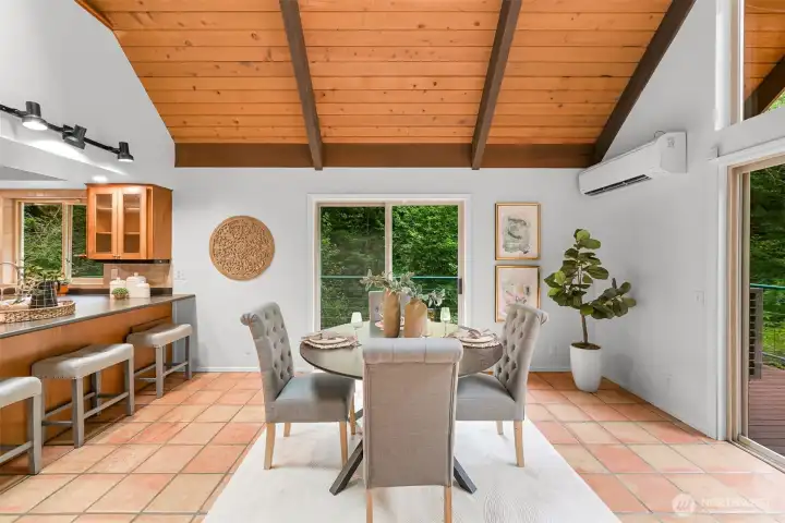 Dining area offers deck access and wooded views, creating an inviting space for meals and gatherings. Dining area offers deck access and wooded views, creating an inviting space for meals and gatherings.