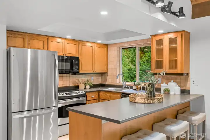 Spacious kitchen features abundant cabinetry, breakfast bar seating, and an open layout overlooking the main living areas. Spacious kitchen features abundant cabinetry, breakfast bar seating, and an open layout overlooking the main living areas.