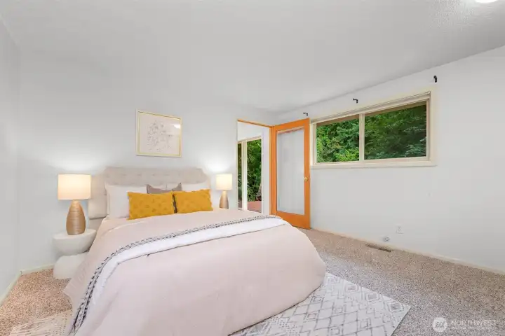 Main-level bedroom offers a comfortable space, abundant natural light, and direct access to the outdoor deck. Main-level bedroom offers a comfortable space, abundant natural light, and direct access to the outdoor deck.