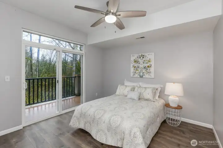 Spacious primary suite with private deck overlooking mature trees.