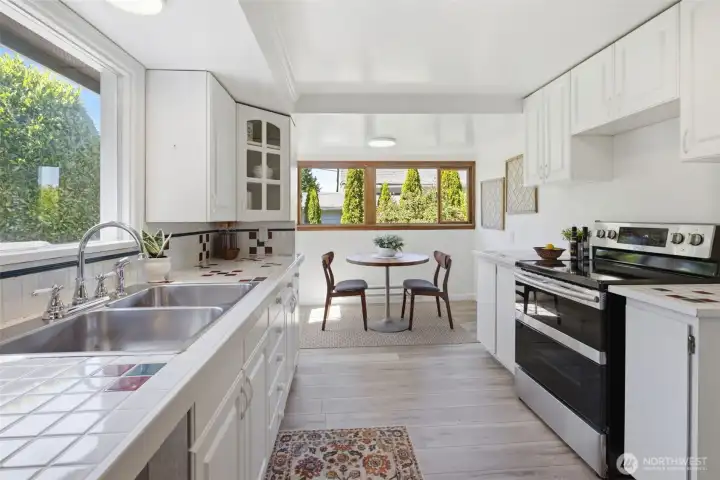 This cozy kitchen nook is bathed in natural light, making it the perfect spot to start your day. There is a door to the left of the table that flows out to the entertaining deck off the kitchen.