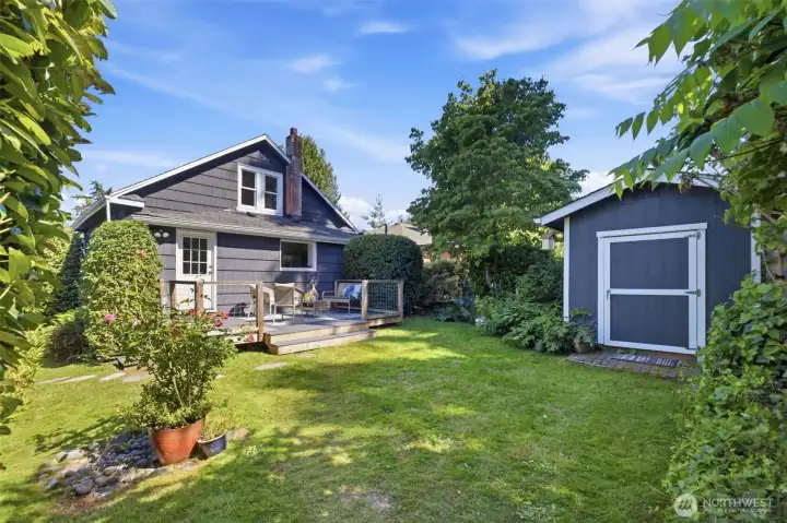 This spacious, private backyard features lush landscaping, an ideal deck for entertaining, and additional storage space for all your gardening and yard tools.
