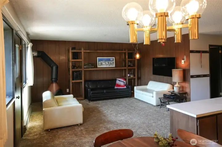 Living room with rich wood paneling & built-in shelving. Living room with rich wood paneling & built-in shelving.