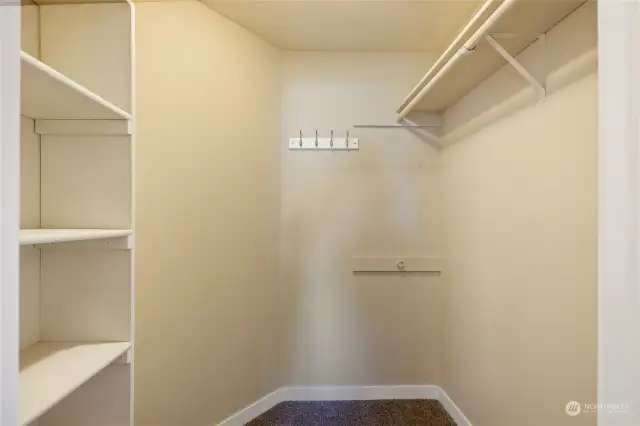 Large walk in closet with built in shelf.