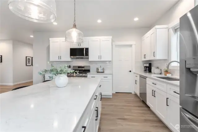 Beautiful quartz countertops with tiled backsplash.