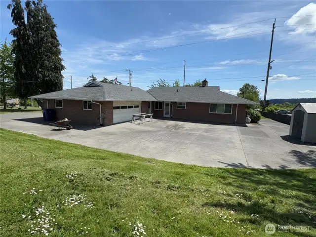 Rear view of main home with huge aggregate patio and note the drive-thru garage...
